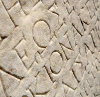 Image of stone carved roman and greek letters.